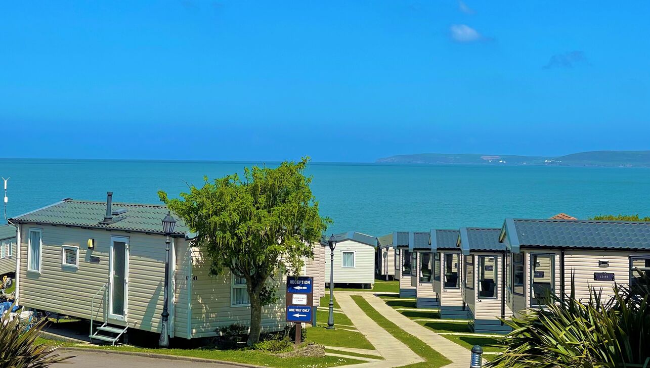 A Row of Caravan Holiday Homes with the Sea in the Background