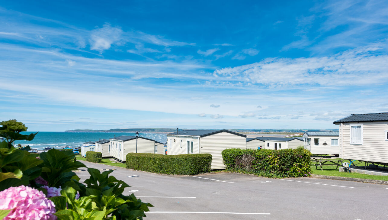 Rows of Holiday Homes, Flowers and the Beach in the Distance