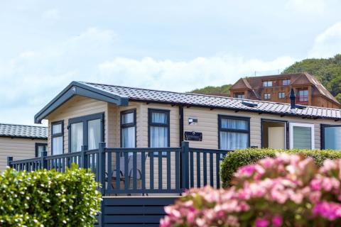 Holiday Home with Outdoor Decking area surrounded by Bright Flowers