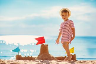 Child making sandcastle on beach